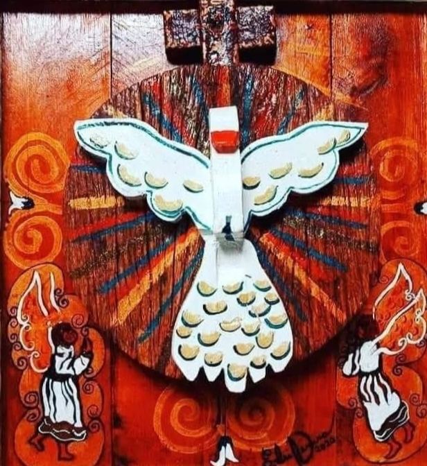 Close view of an oratório: a white dove with open wings on a disc of rays, a cross on top and an angel among spirals on each side