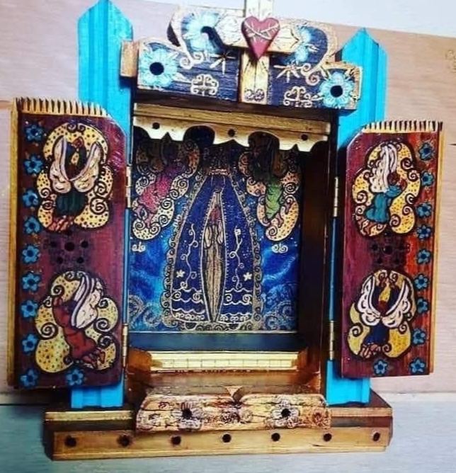 Open oratório between turquoise pillars, with Our Lady of Aparecida on a blue background, angels on the doors and a heart on top