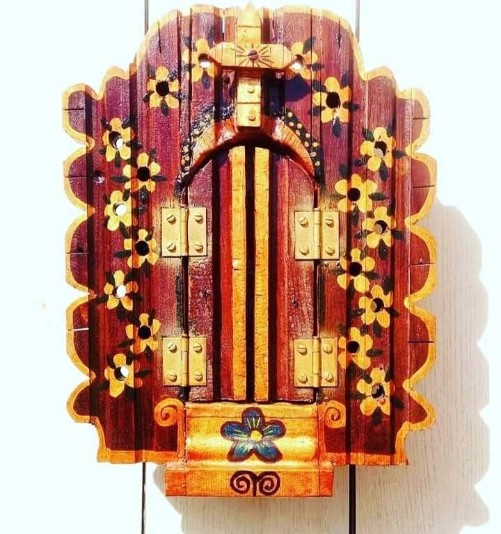 Closed burgundy oratório with a cut-out outline, painted yellow flowers and golden hinges